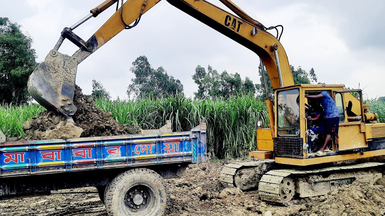 veku 142 ভেকু গাড়ি দিয়ে নদীর পাড়ের মাটি কেটে ট্রাক্টর দিয়ে সরিয়ে নেওয়া হচ্ছে