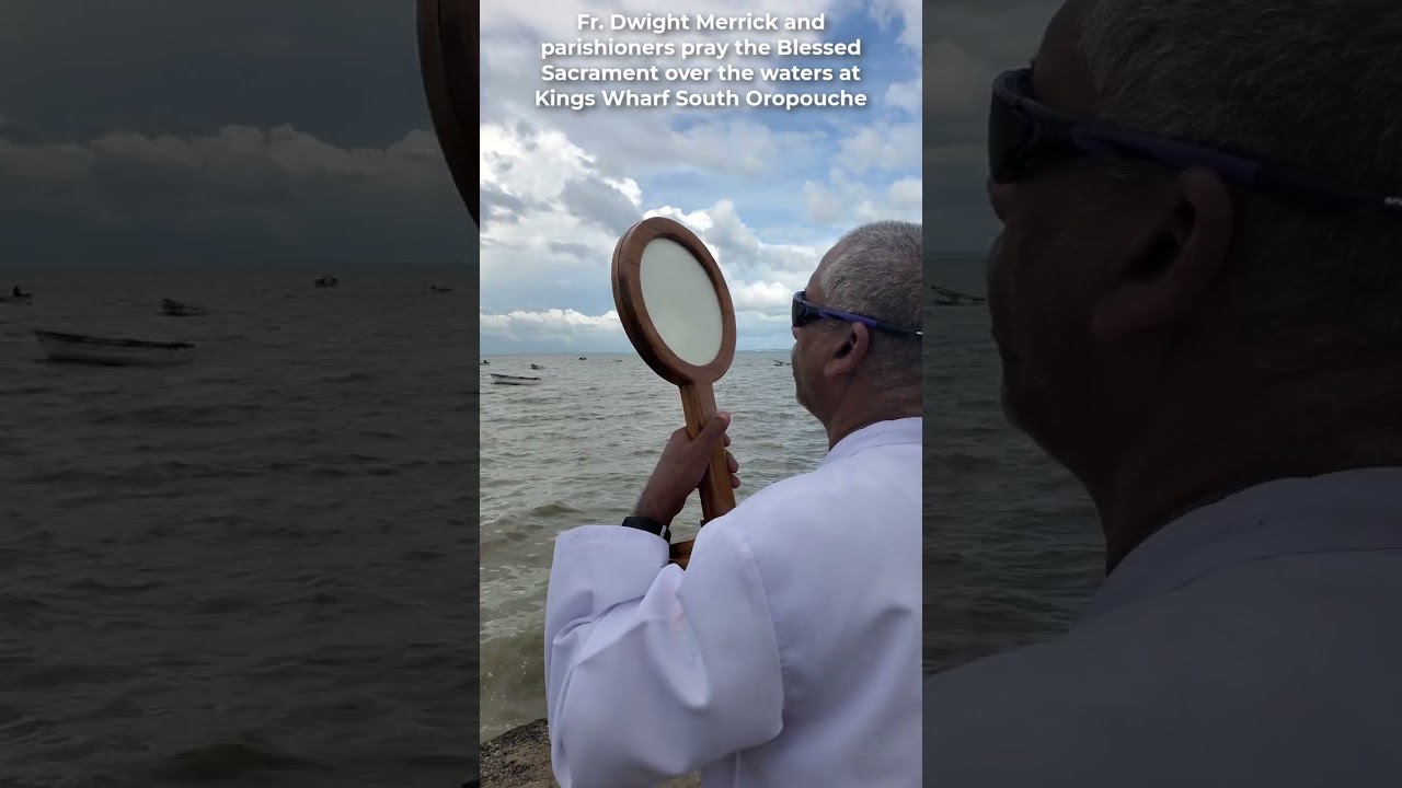 Fr  Dwight Merrick and parishioners pray the Blessed Sacrament over the waters at Kings Wharf South