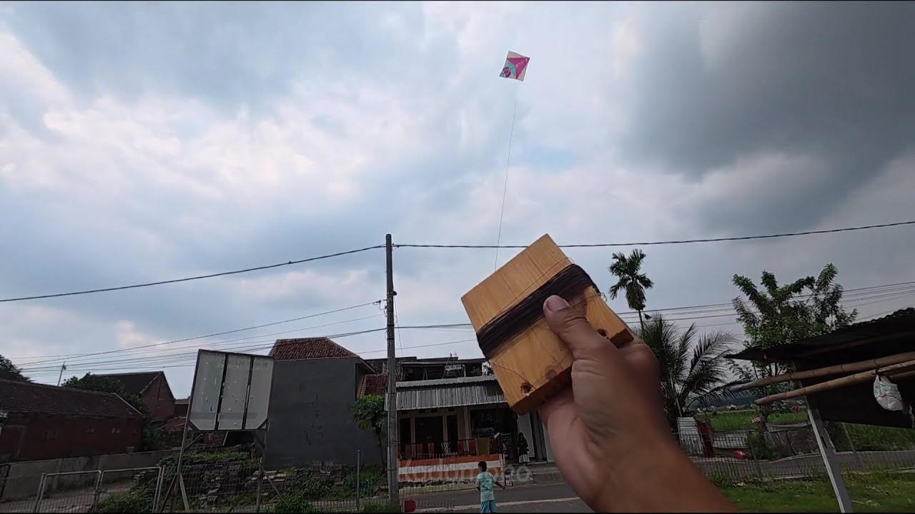 Main nerbangin layangan pakai satu tangan