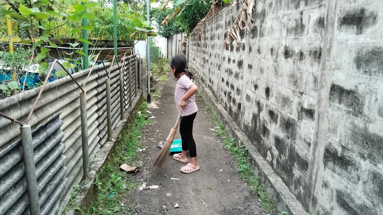 Kaka hibi bersihin rumput dan sampah di gang depan rumah