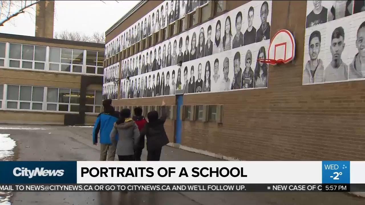 Portraits of students and staff line school wall