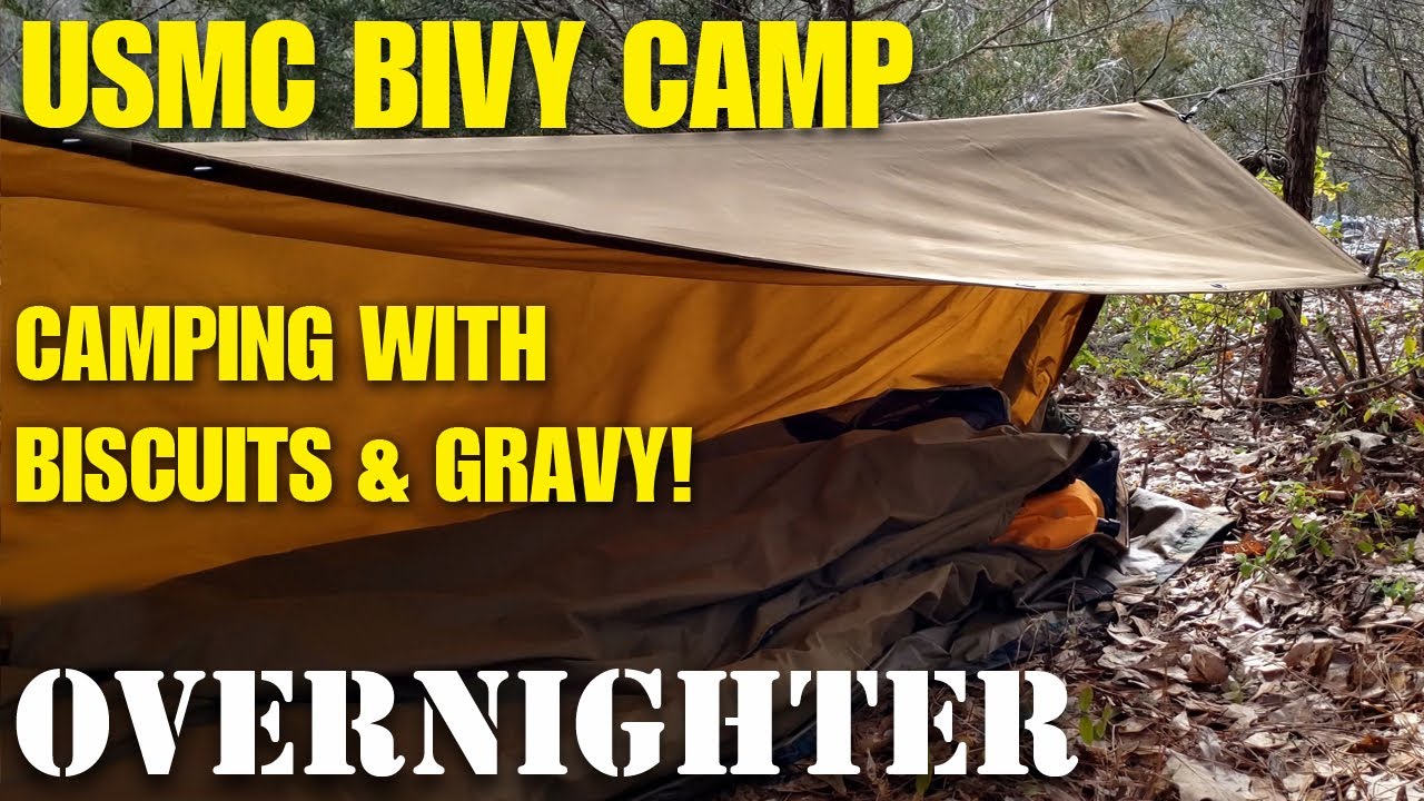Father and son bushcraft camping in USMC bivy and sleeping bag