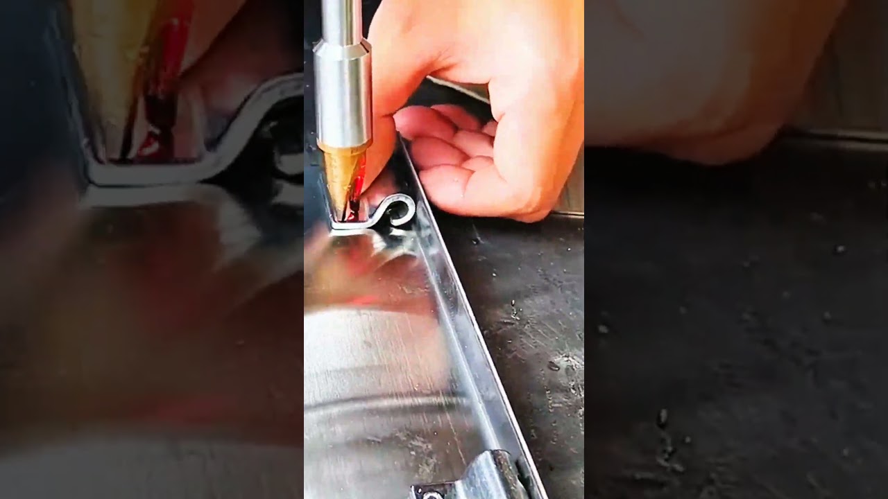 Gloved hand steadies pipe&mdash;marked slit guides rhythm of tab, join, and metal locks firm with crafted
