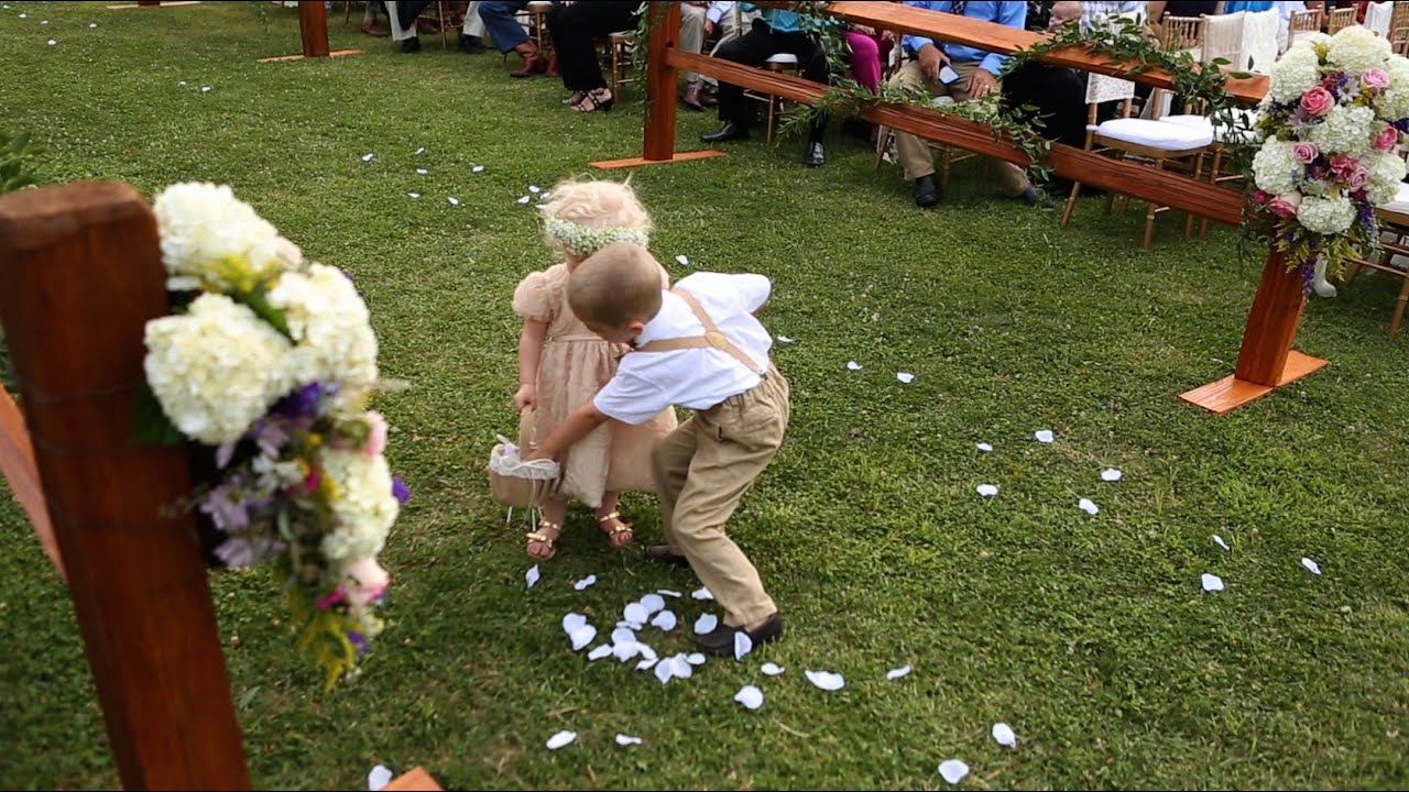 Cute! Ring bearer stops to help flower girl during wedding