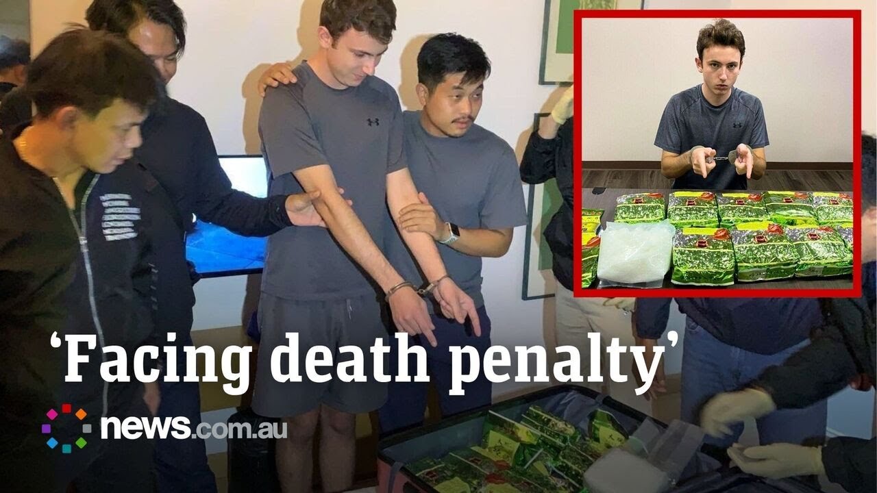 Thai police make alleged smuggler point at drug pile for photos