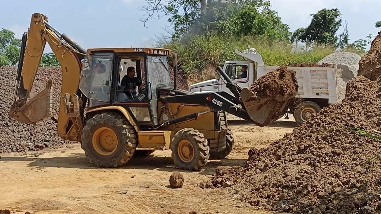 Caterpillar 426C Backhoe Loading Dump Truck And Moving Material 