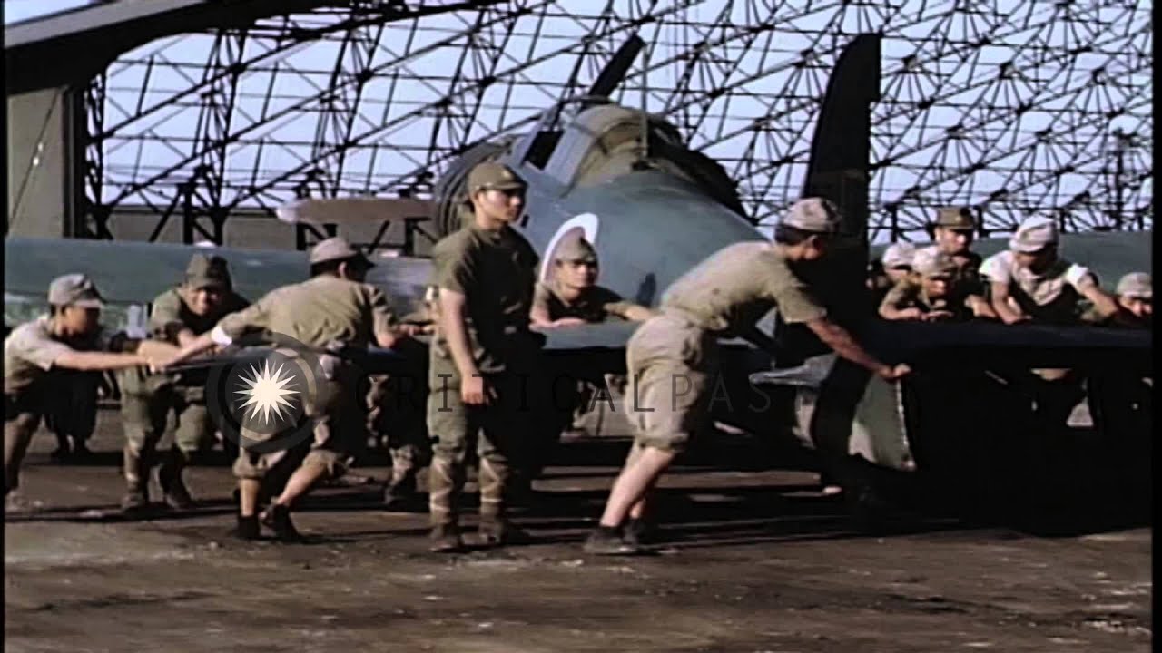 Japanese soldiers push Japanese fighter plane into hangar at Atsugi Airdrome in J...HD Stock Footage