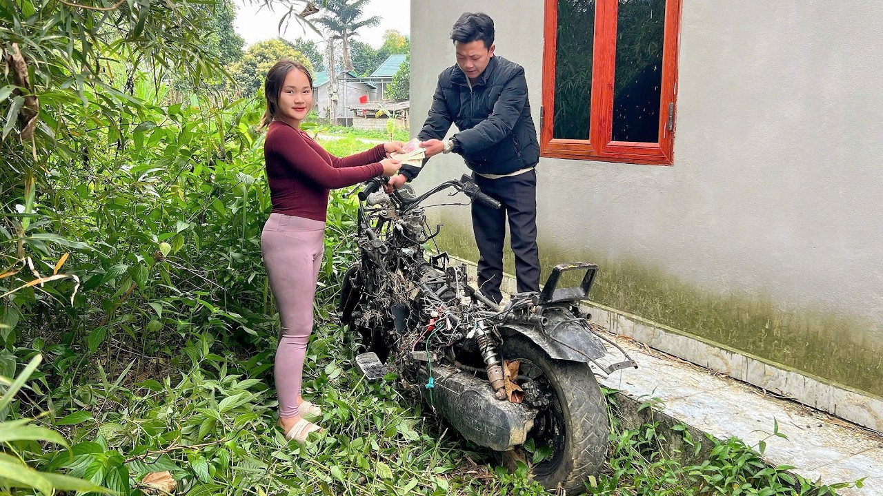 Girl repairs and restores old broken and rusty scrap motorbike.