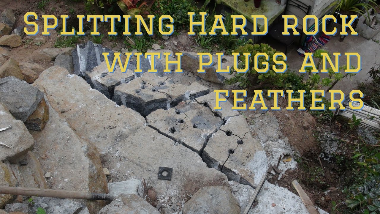 Splitting hard rock with plugs and feathers