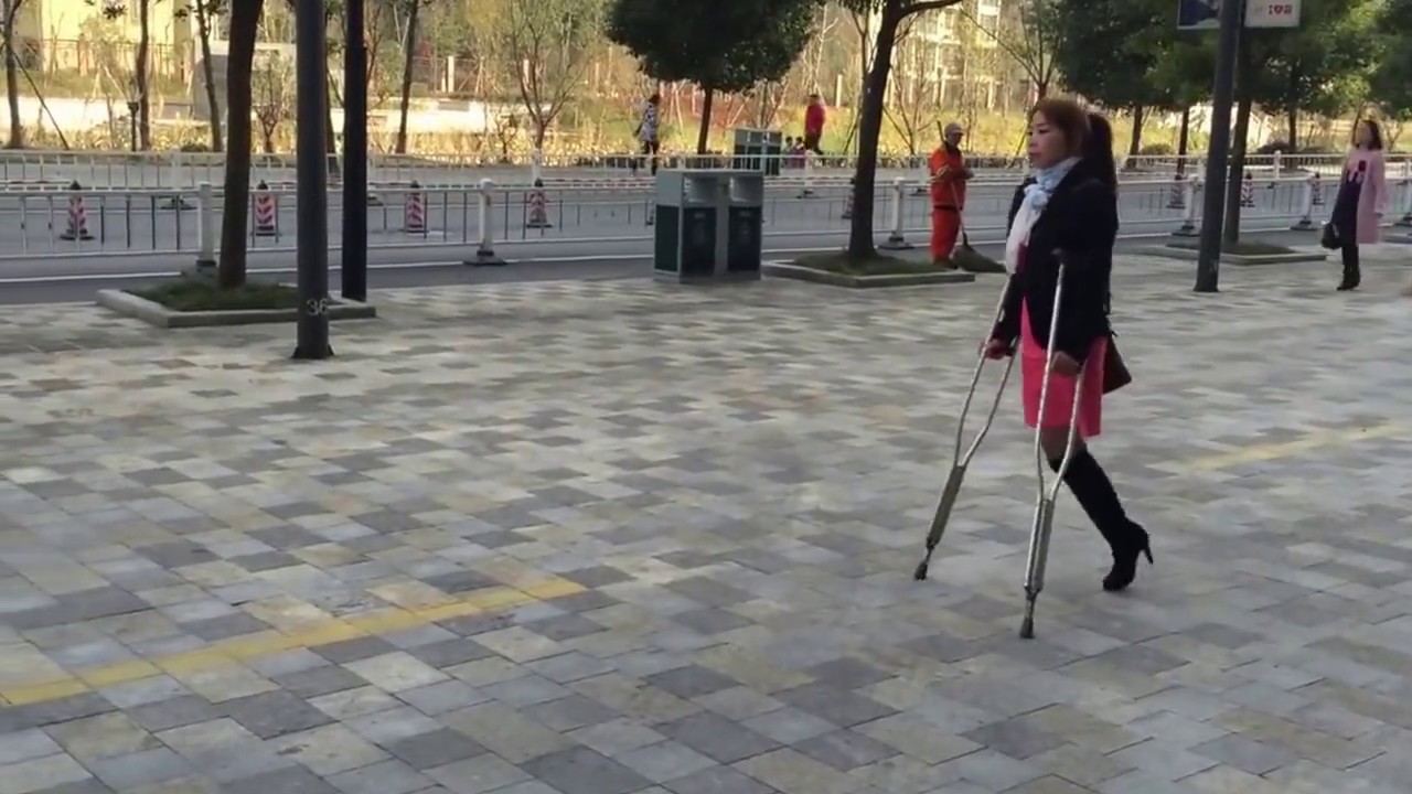 Amputee woman street crutching