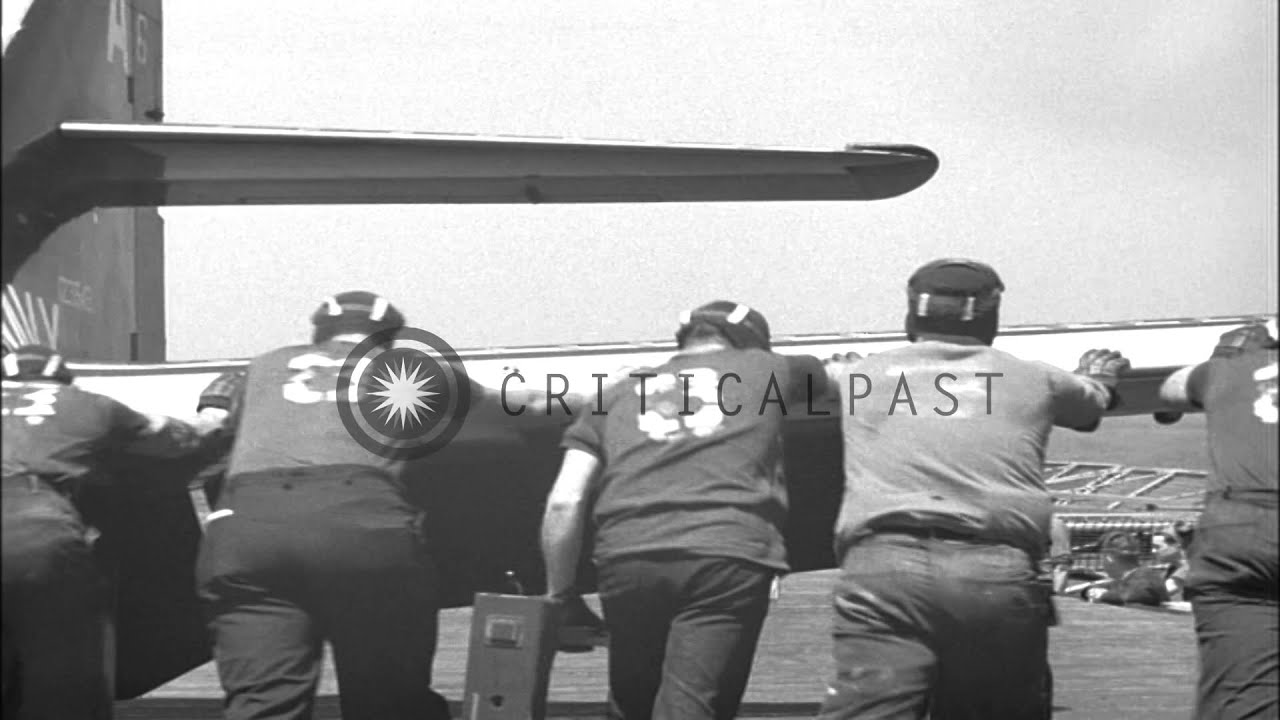 Men roll the jet plane on the flight deck at sea in United States. HD Stock Footage