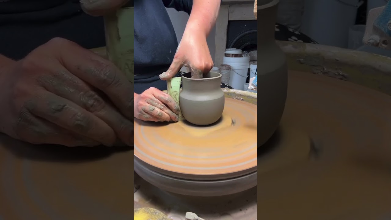 Throwing a curvy mug of the potters wheel with a profile rib I made.