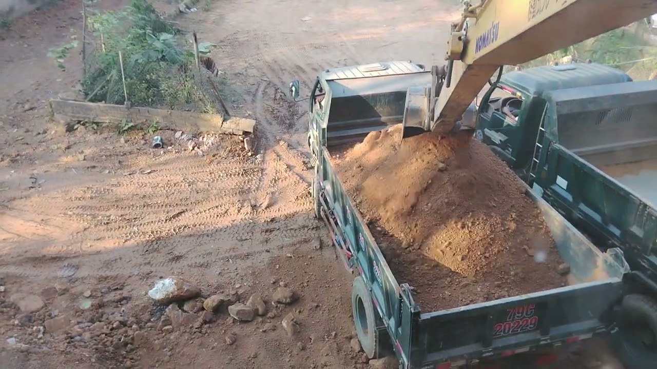 Máy xúc đào làm đường xúc đất lên xe 