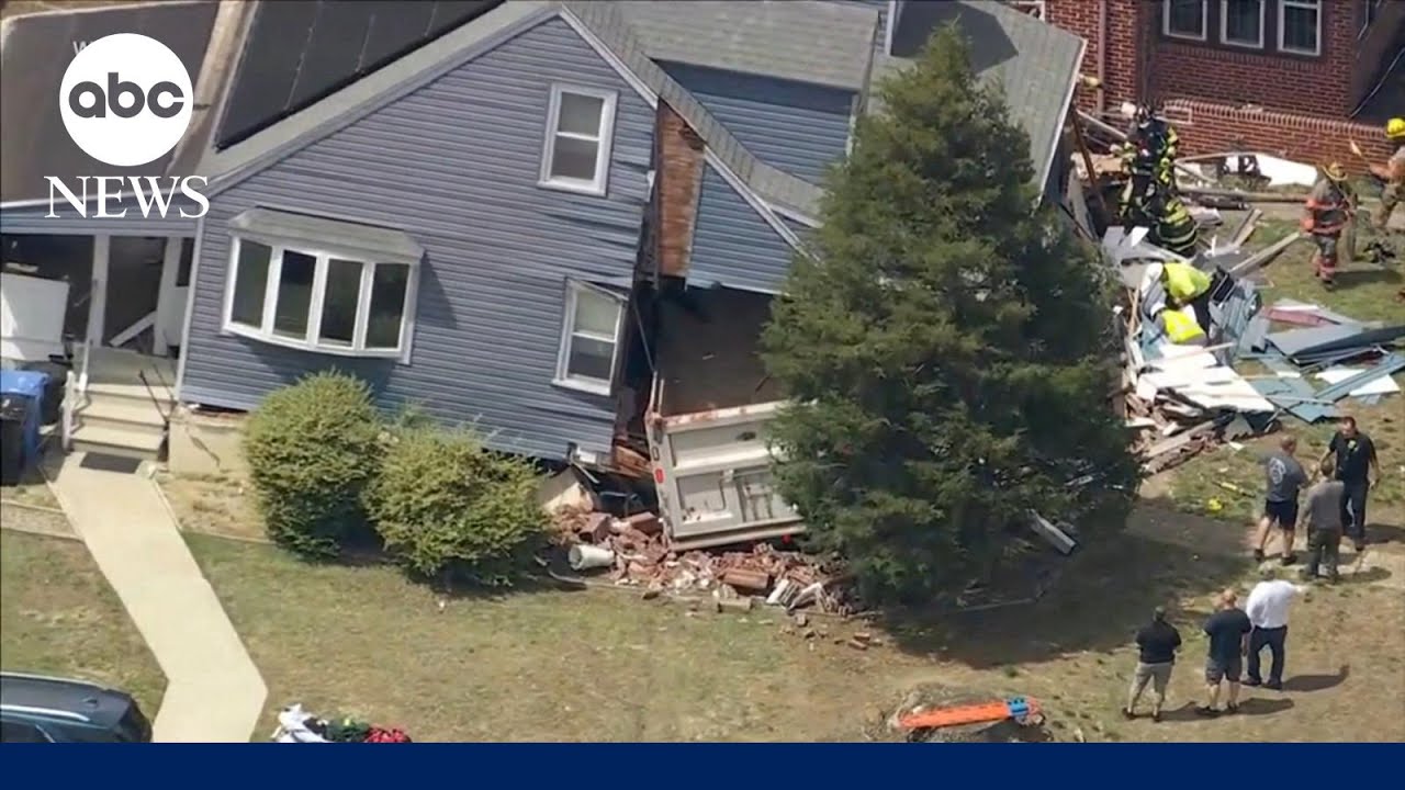 Driver trapped after dump truck slams into home