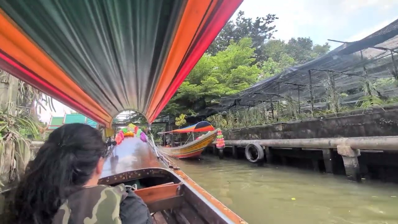 Longtail boat down the river khlongs from Lat Mayom Floating Market to Wat Arun, Bangkok.
