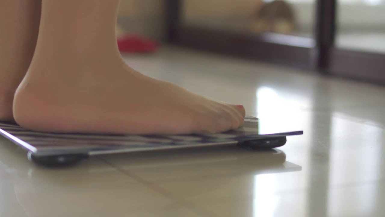 legs of the girl stand on the scales
