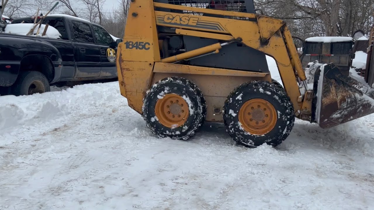 Case 1845c skid steer plowing a foot of snow