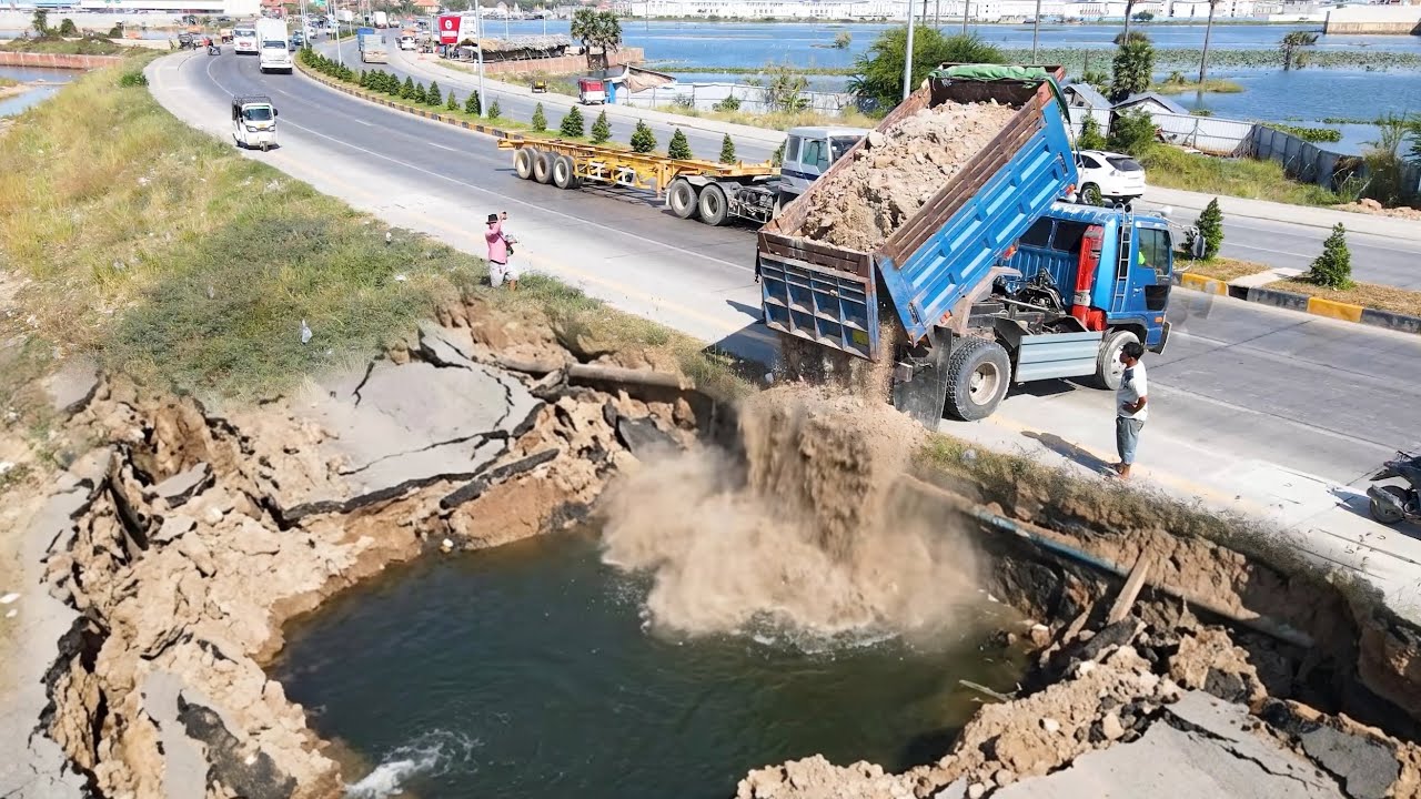 Great job !! Dump truck unloading soil landfilling nearly road with bulldozer working push soil fill