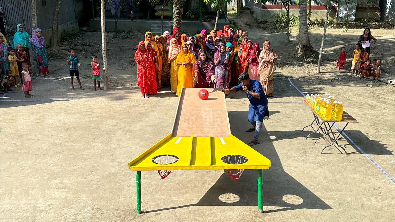 আজব খেলায় পুরস্কারের ছড়াছড়ি। গ্রামের মহিলারা কাঠের রাস্তায় বল গড়িয়ে ৫ লিটার তেল জিতে নিলো