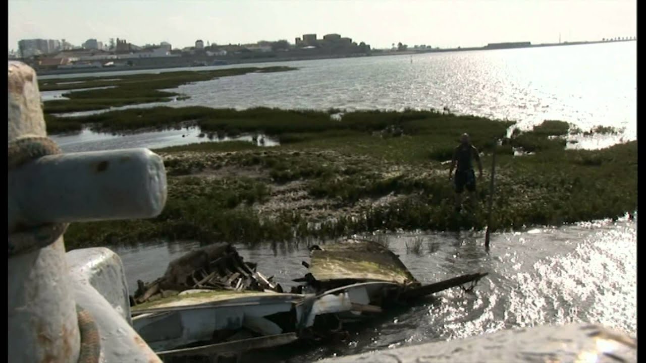 Salvaging the remains of a sunken boat that was beached in the Ria Formosa in Faro Portugal