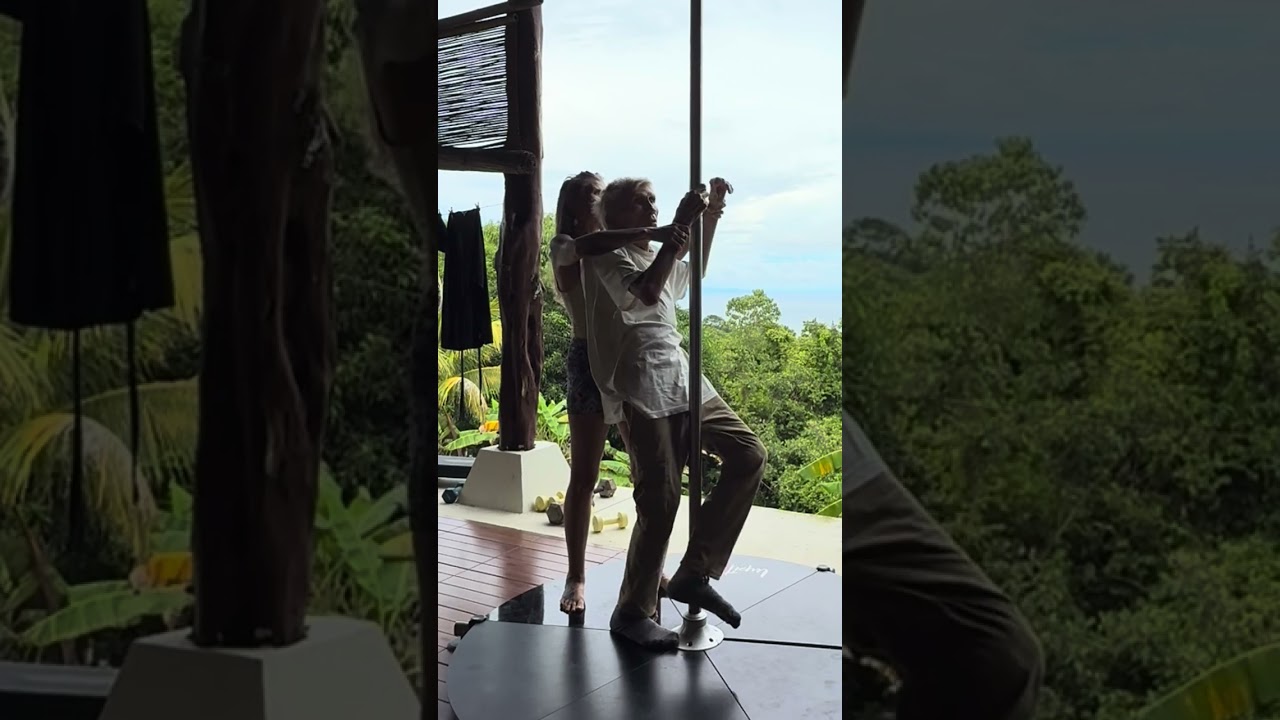 Viktoras Kulvinskas practices Polistic Pole Yoga with Jenesis Dixon in Montezuma, Costa Rica 