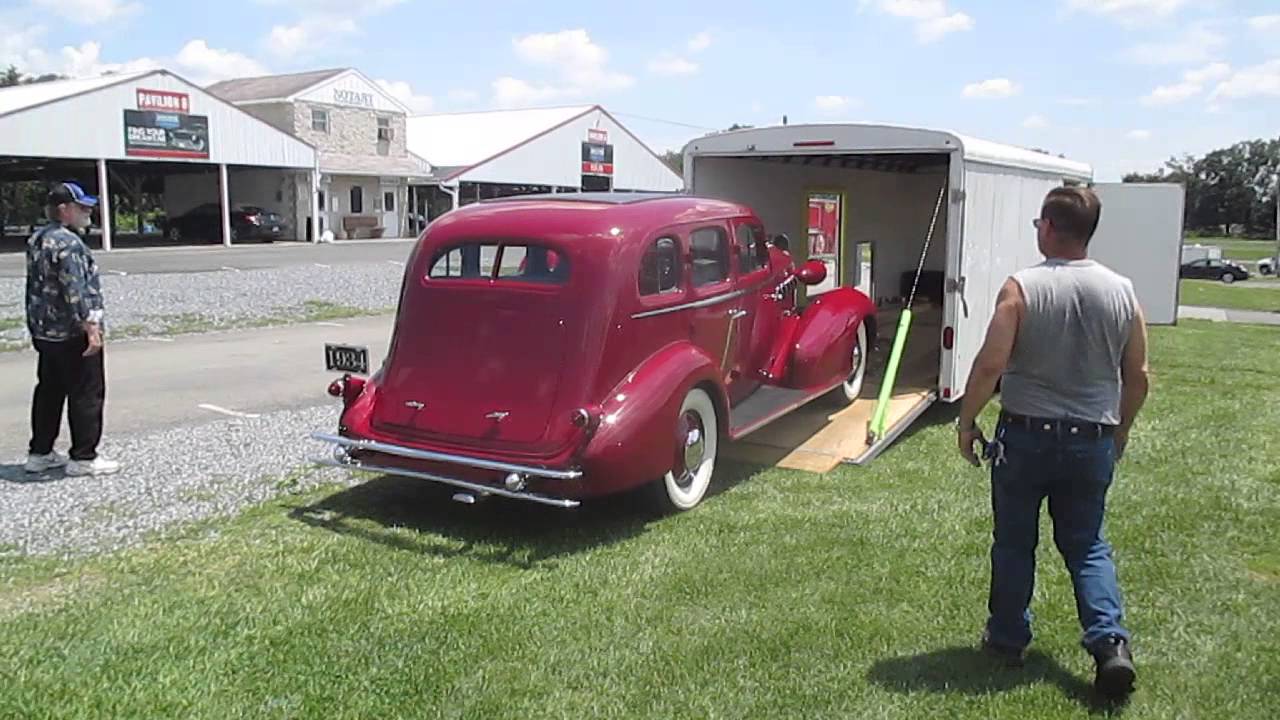 The owner of a really old, beautiful and valuable car trying to get it on to a trailer