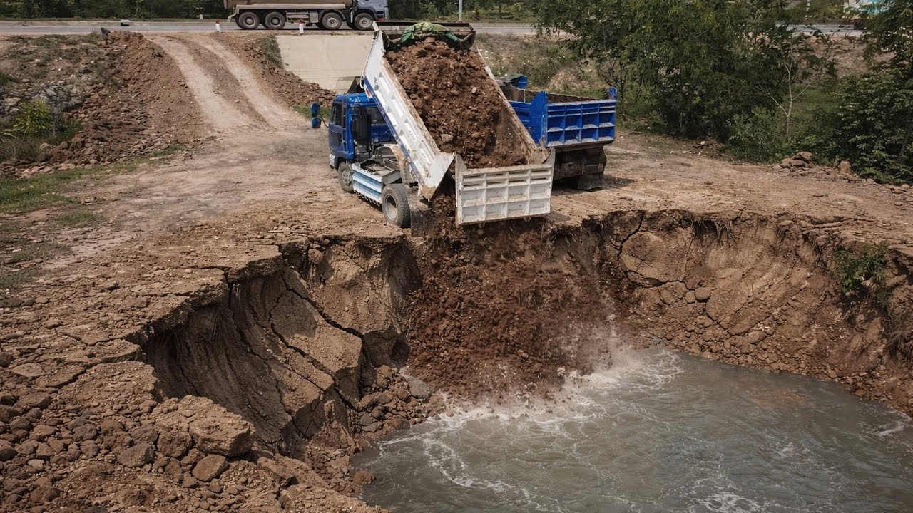 Small Dump Trucks Loading Soil Filling Small Lake With Mini Bulldozer