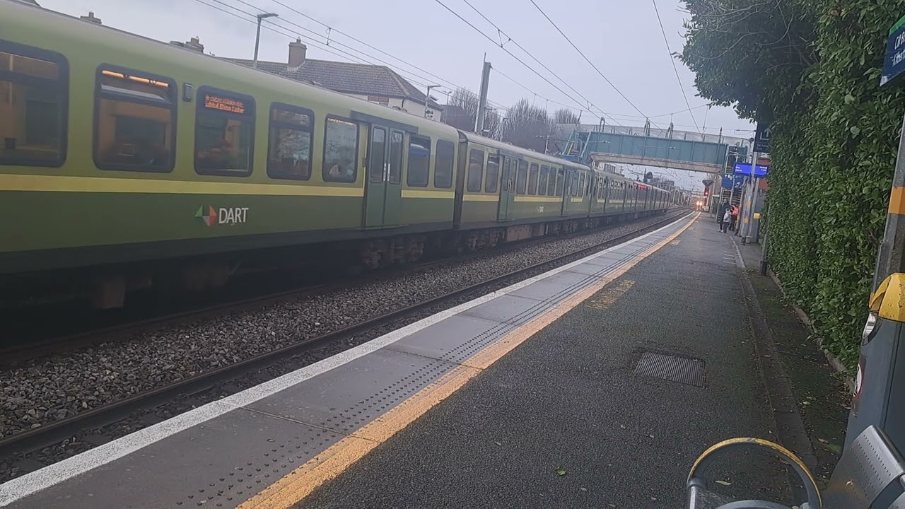 Irish rail dart train arrives at and departs Kilbarrack for Howth and 29000 class train passes