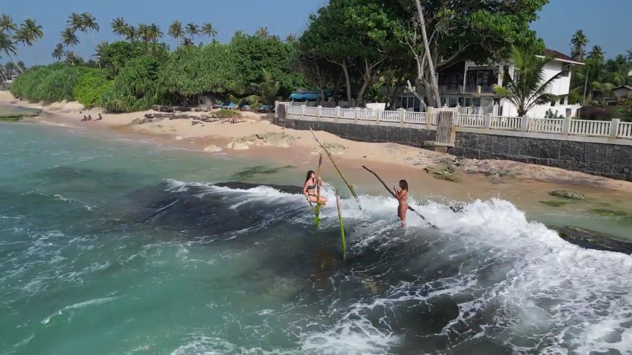Ladies using fisherman sticks for a photosession, Ahangama, Sri-Lanka