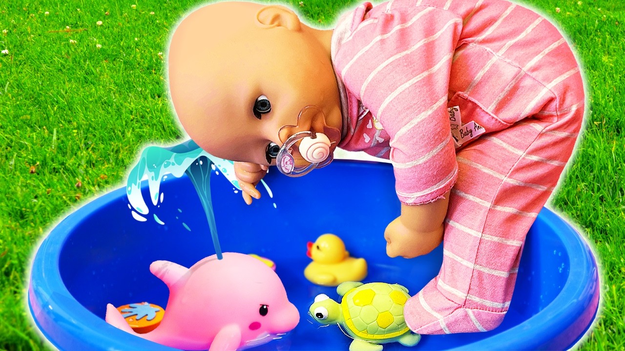 A baby doll and her nanny play with water and toy accessories in a playful setting.