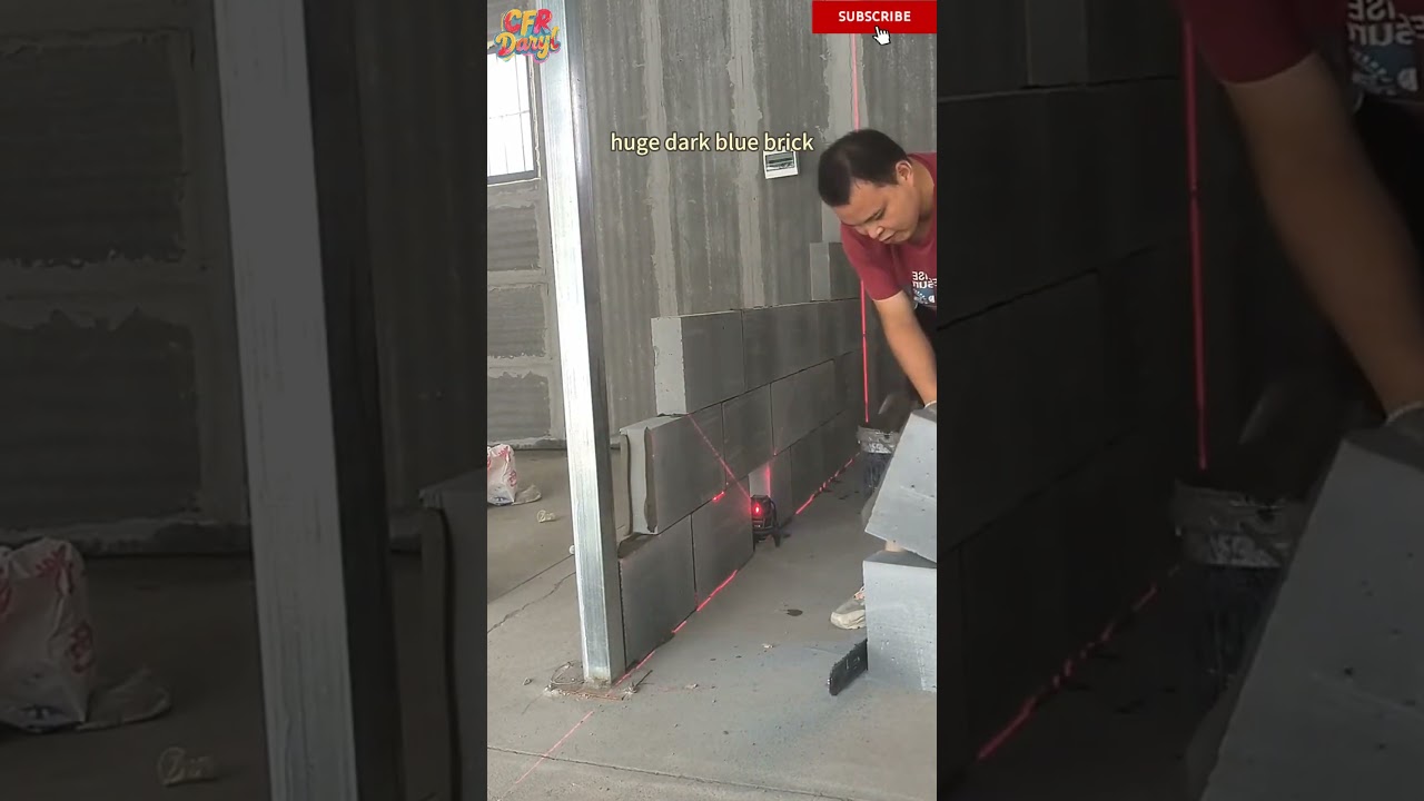 Professional bricklayers use lasers to build huge dark blue brick partitions at their locations