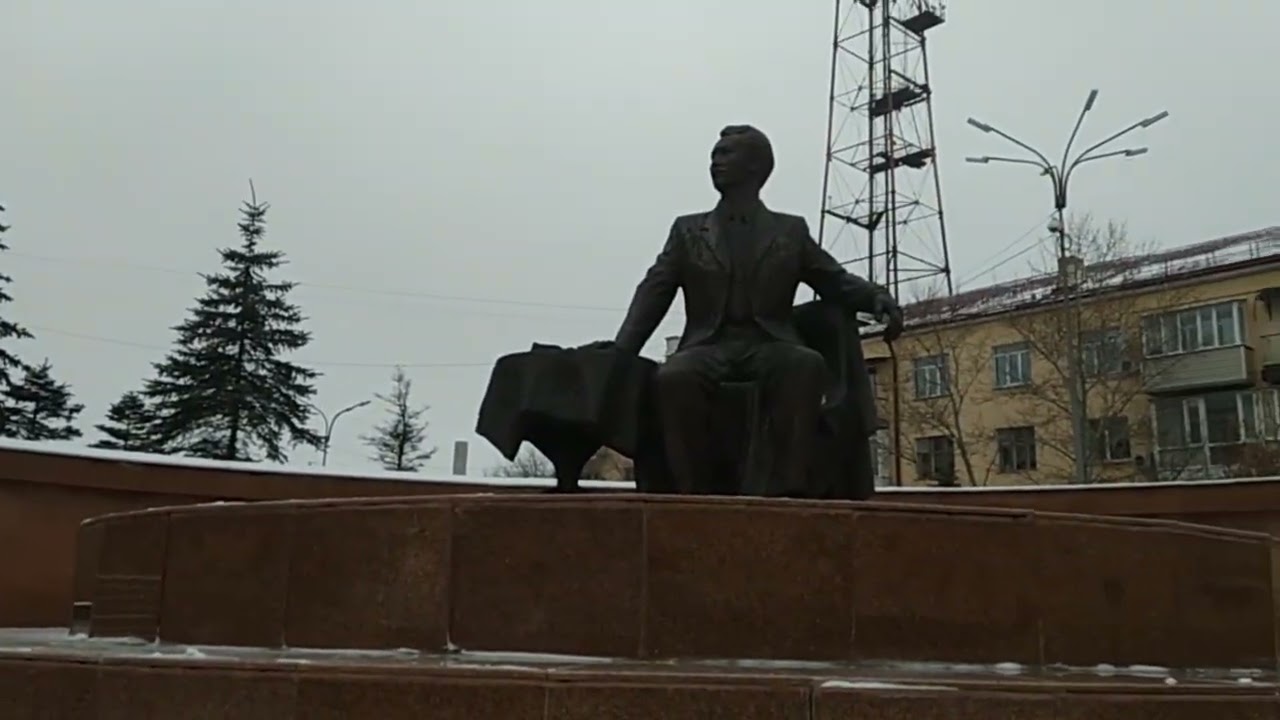 Памятник Сакена Сейфуллина около театра 6-ого Января 2026 года, сзади возвышается Телевышка