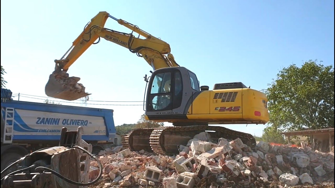 NEW HOLLAND E245 loading MERCEDES AROCS 4146 with demolition debris - Corno di Rosazzo, Italy