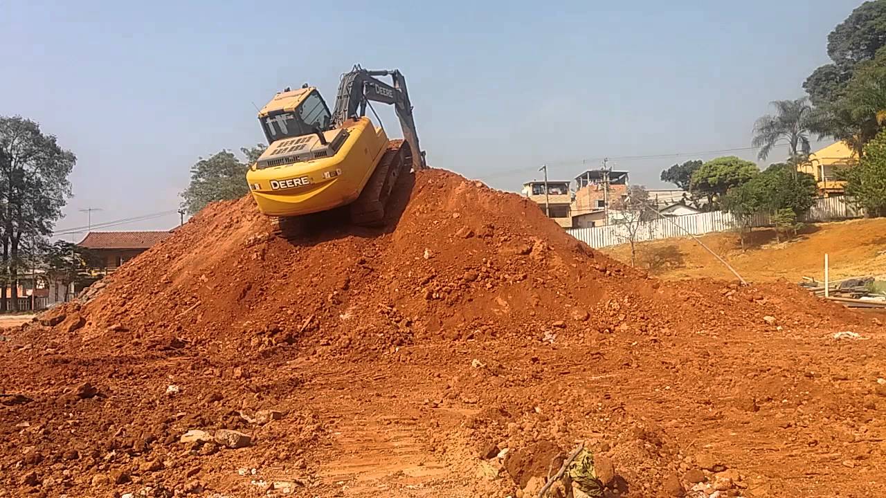 escavadeira subindo no monte terra