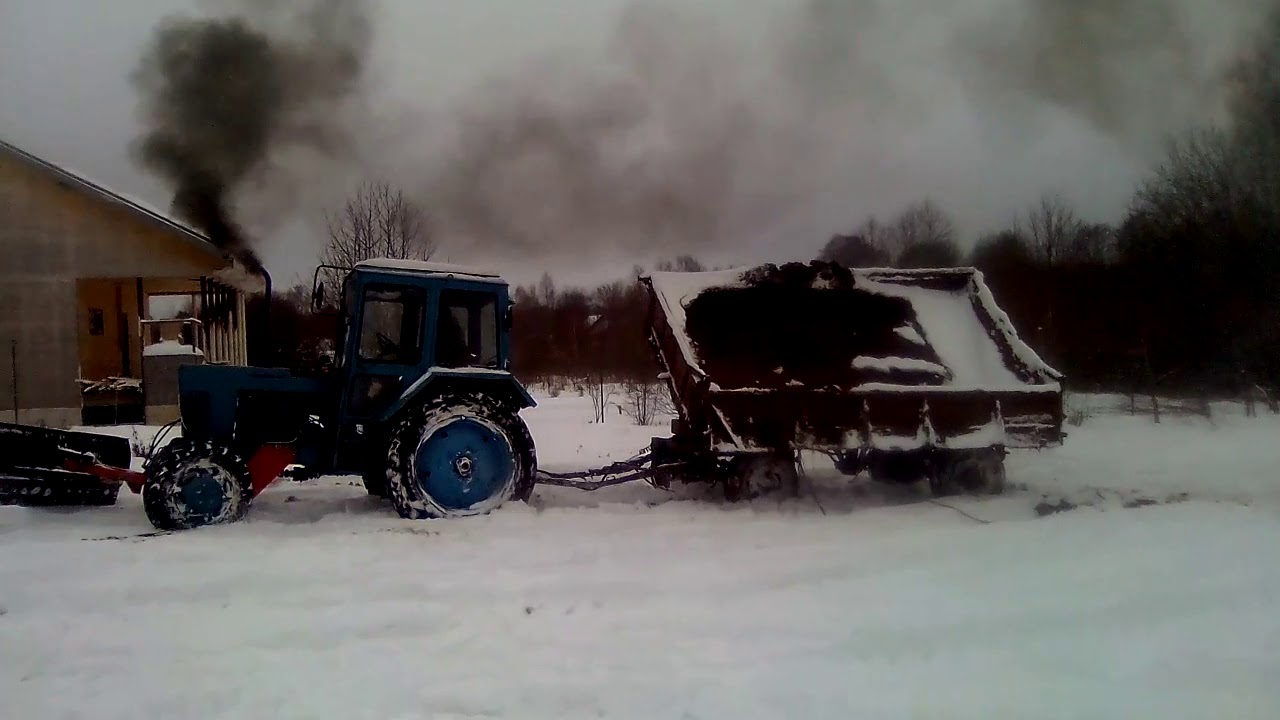 МТЗ82 вывозит замерзший навоз.
