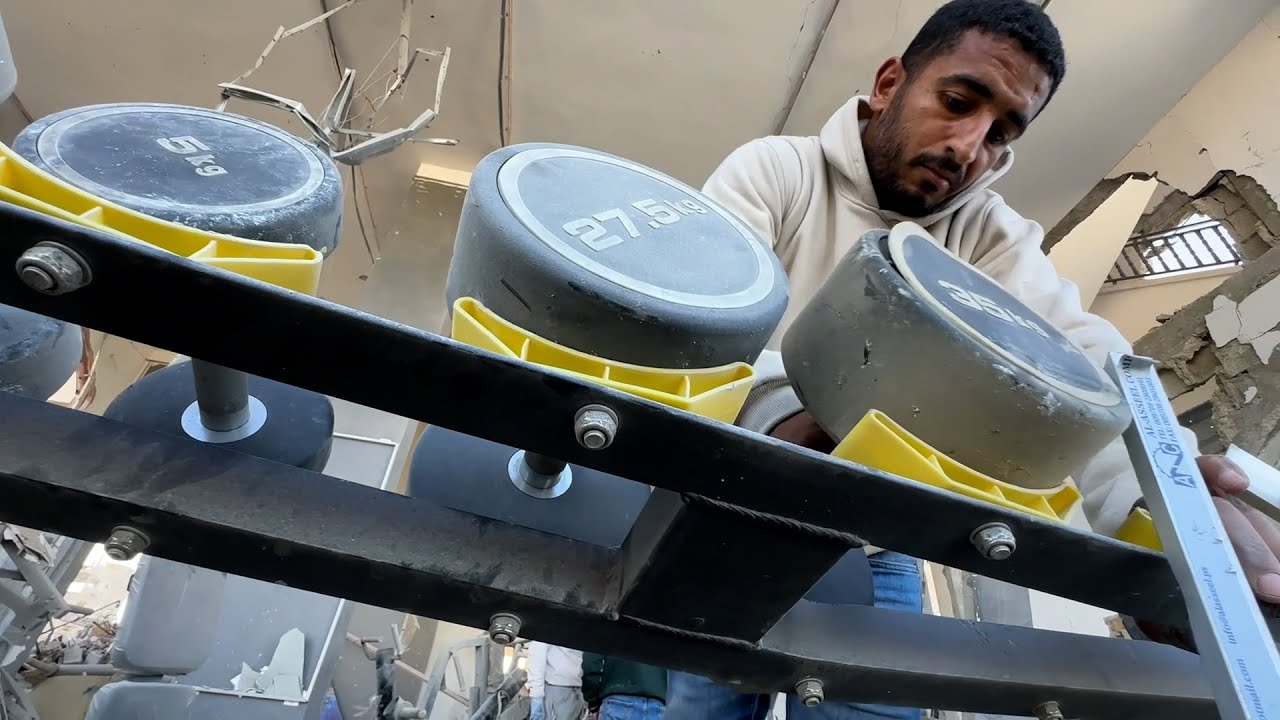 بلال أبو نقيرة يتفقد ناديه الرياضي لبناء الأجسام الذي دمره الاحتلال في مدينة رفح جنوب قطاع غزة