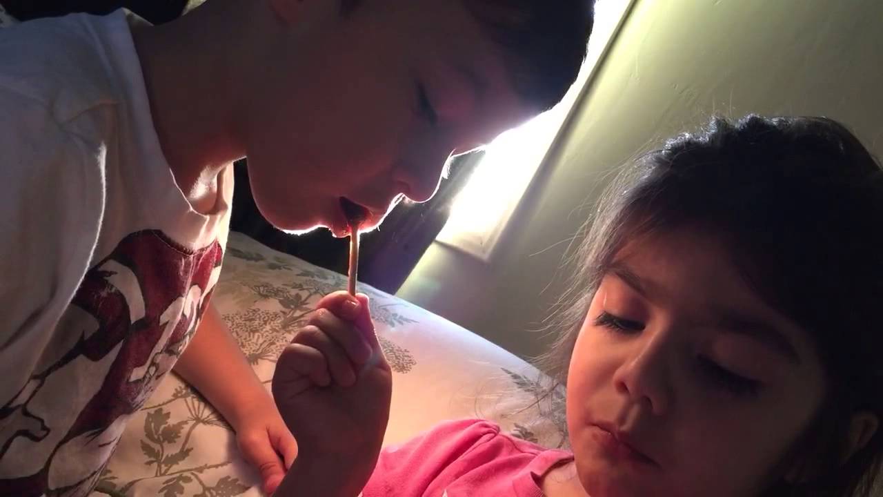 Brother and sister sharing lollipop