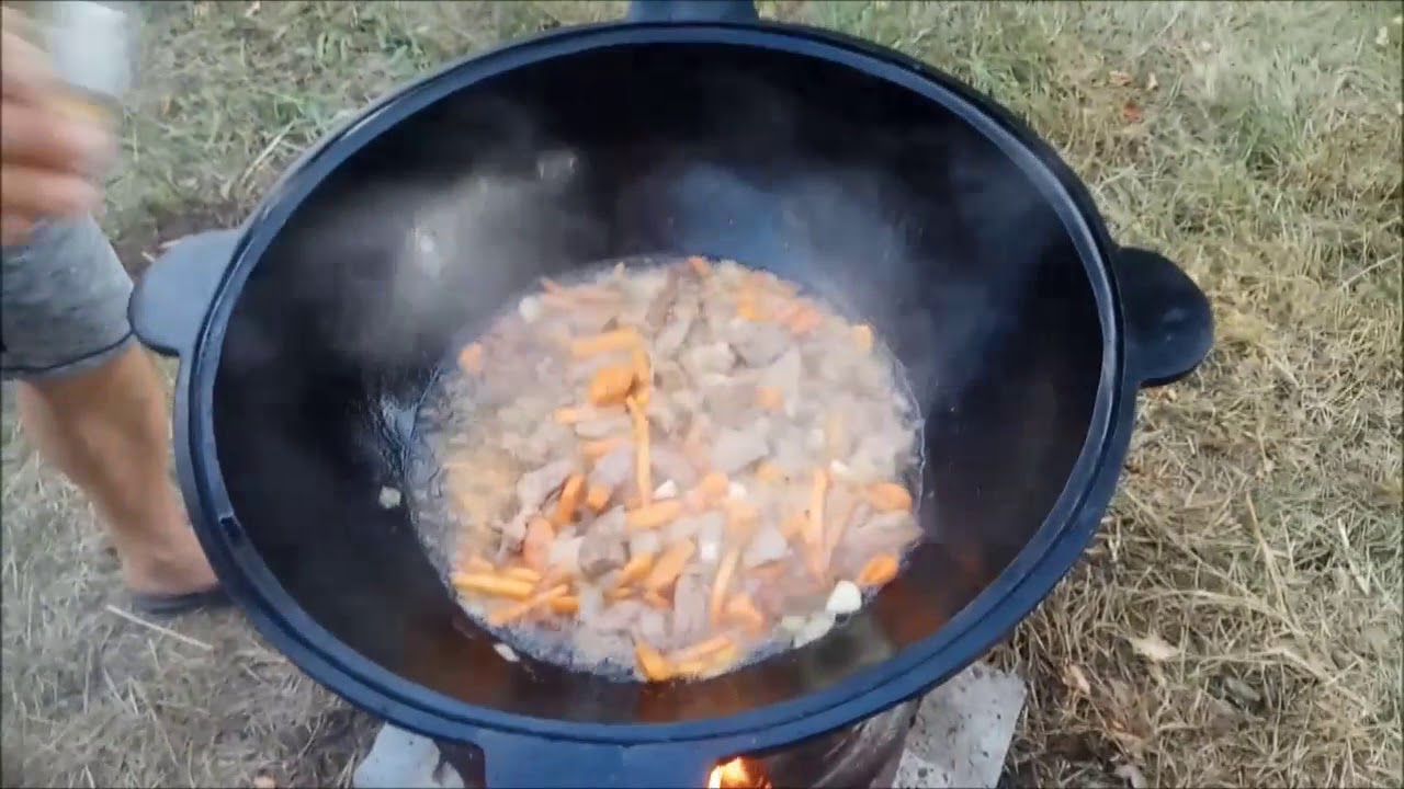 Тушеная свинина с картошкой в казане на огне