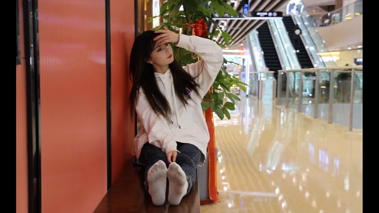 Buhan walks around the mall wearing only white socks, and the bottoms of her socks become very dark