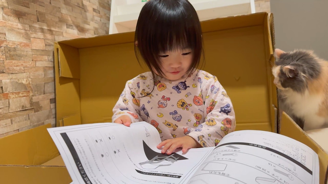 愛猫を巻き込み読めない文字に奮闘する２歳
