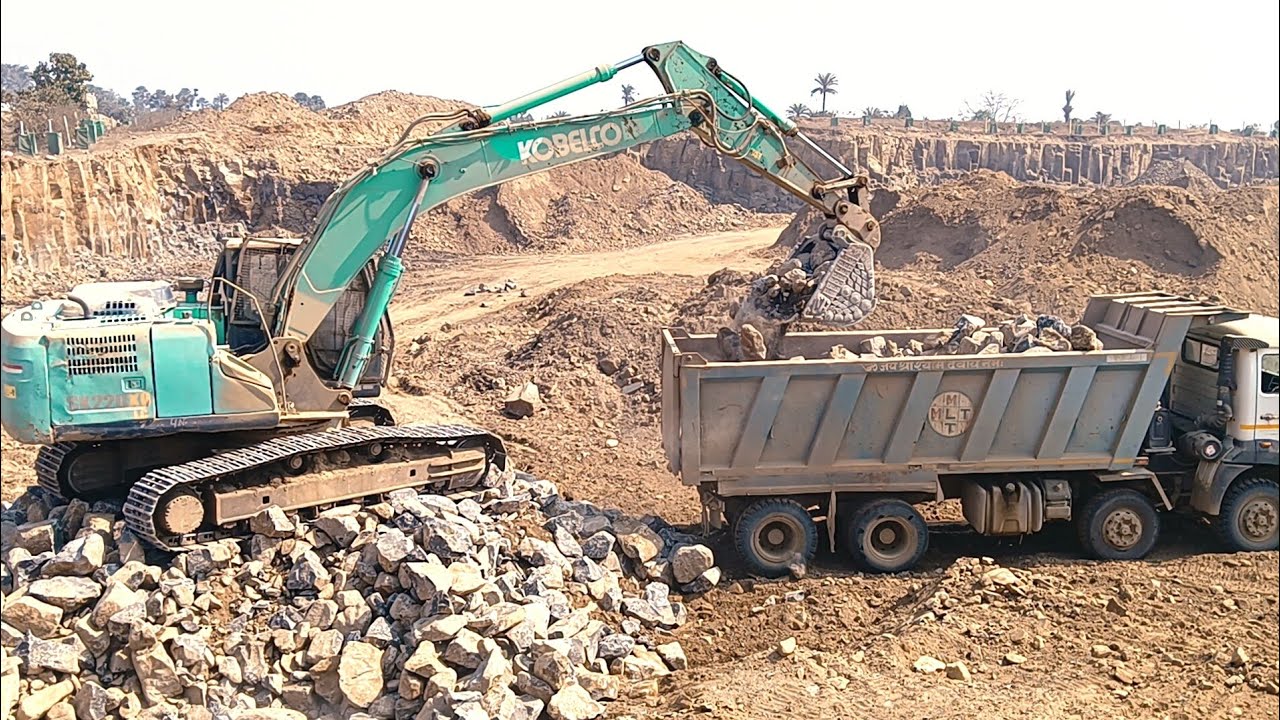 Mines work kobelco excavator machine stone boulder loading on dumper hyva  