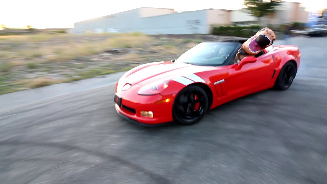 T Rex Dinosaur doing donuts in a Corvette