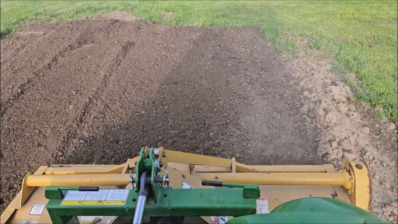 Rototilling topsoil dumped in piles.