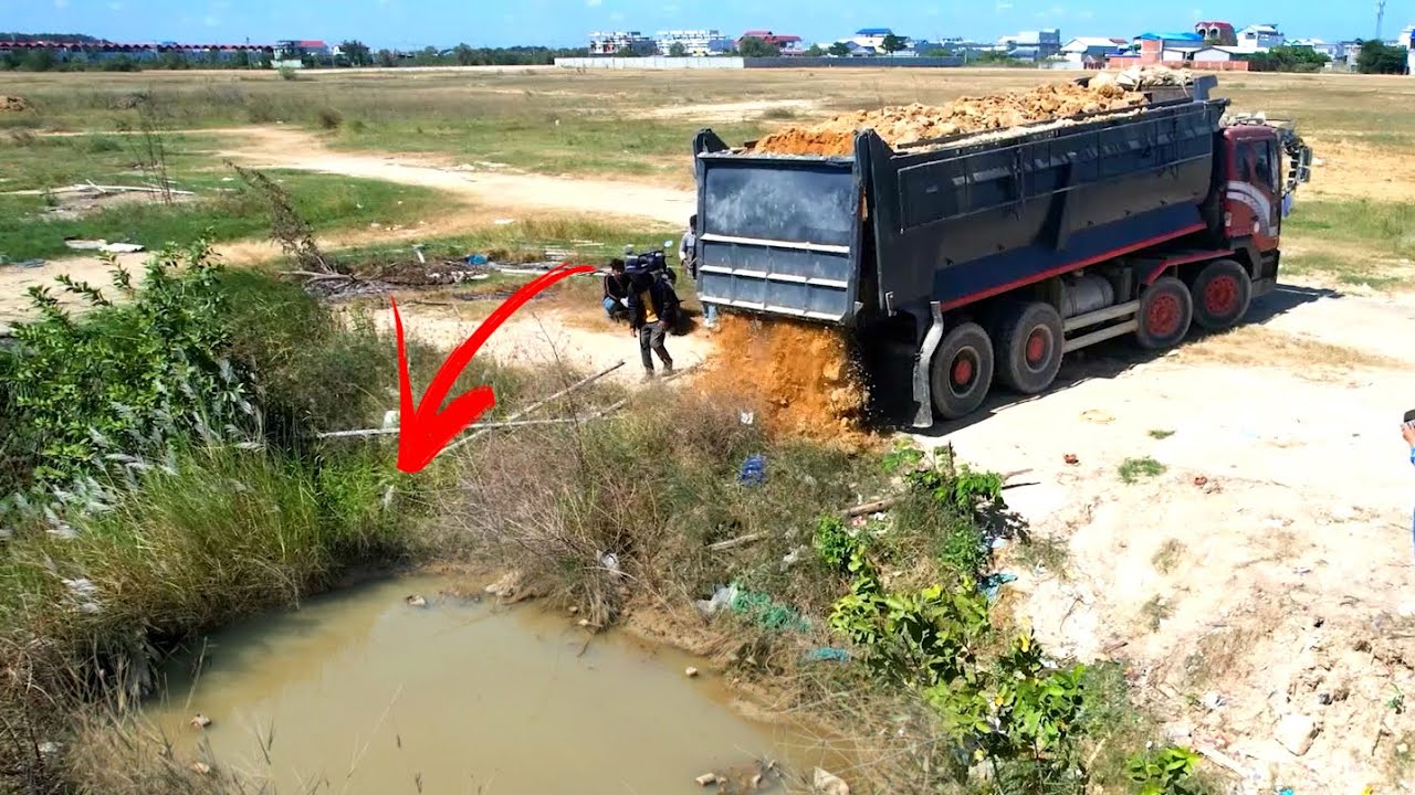 Be careful !! Heavy dump truck unloading soil landfilling up with Bulldozer D41P working push soil 