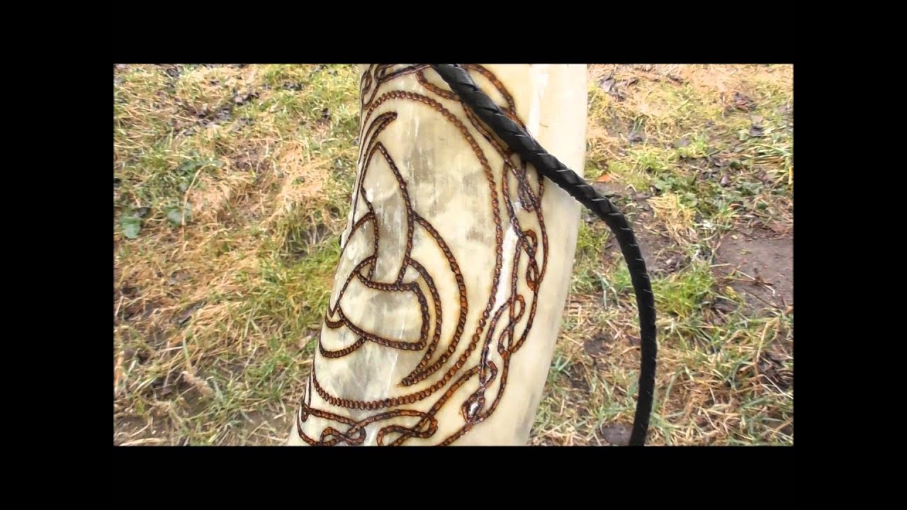 Gebranntes Rufhorn mit geflochtenem Lederriemen.