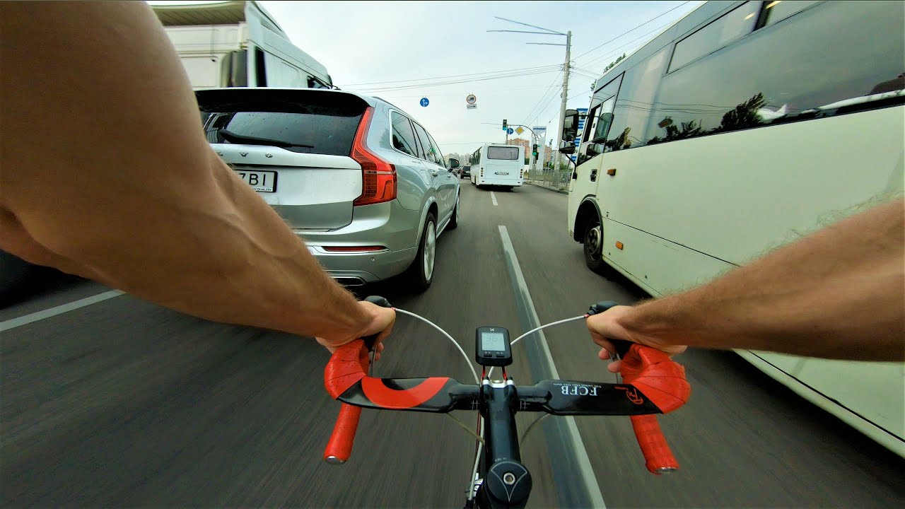 Dangerous ride in the city among cars on a road bike