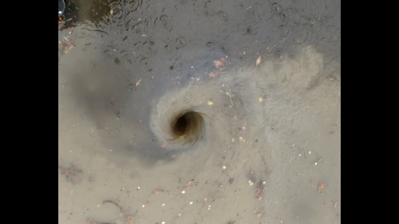 Big whirlpool after clearing a blocked drain. Heavy rain flooded the road until unblocked.