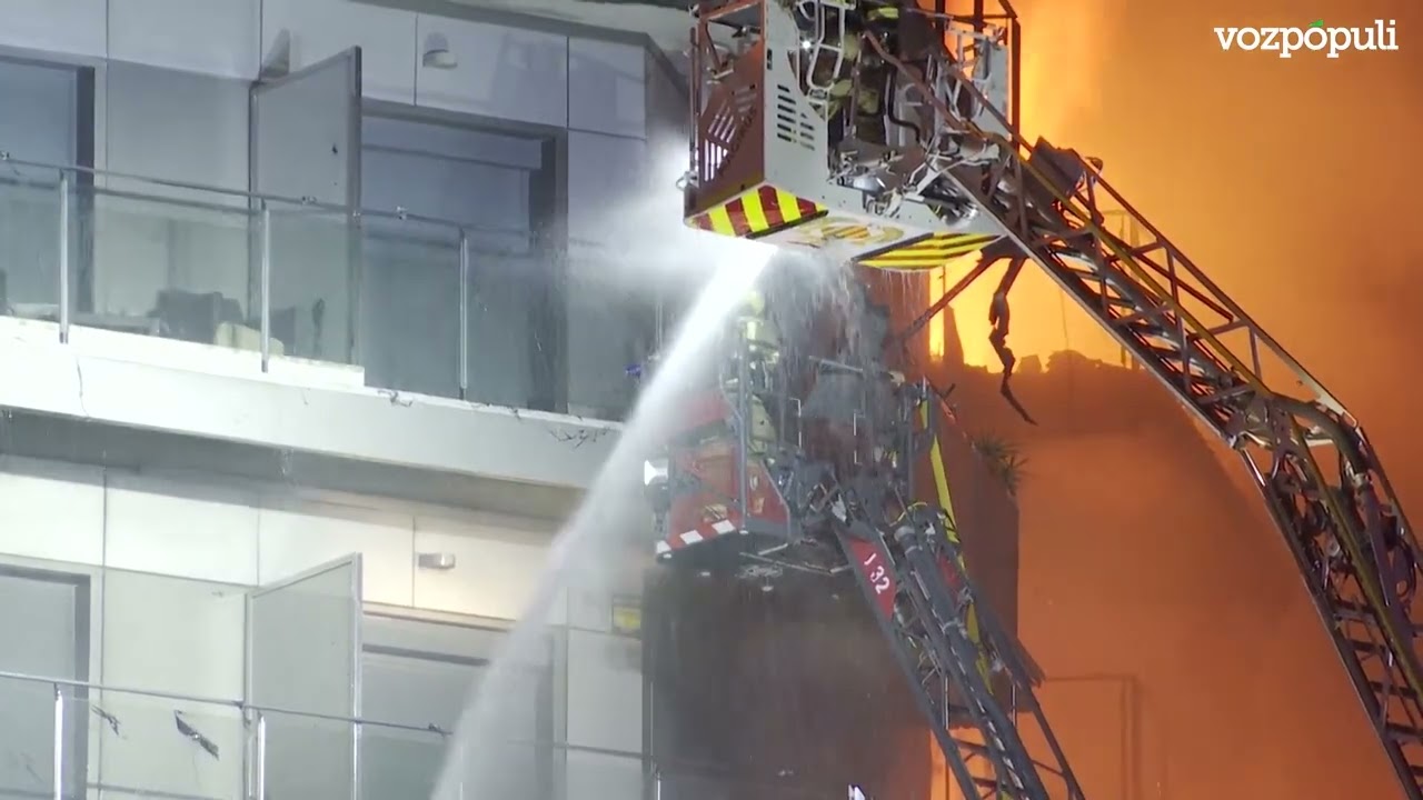 Los bomberos rescatan con dos grúas a dos personas del interior del edificio en llamas en Valencia