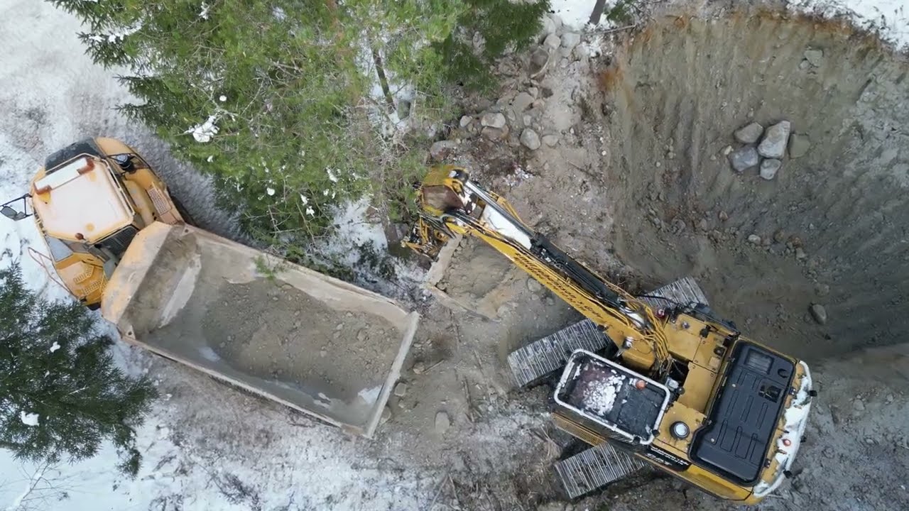 Строительство лесной дороги зимой компанией Emil Johanssons Gräv AB и ее экскаватором Cat.