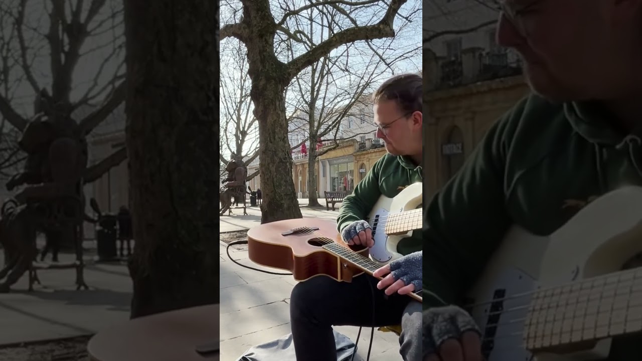 Would you be taking a seat on the bench behind this busker? 